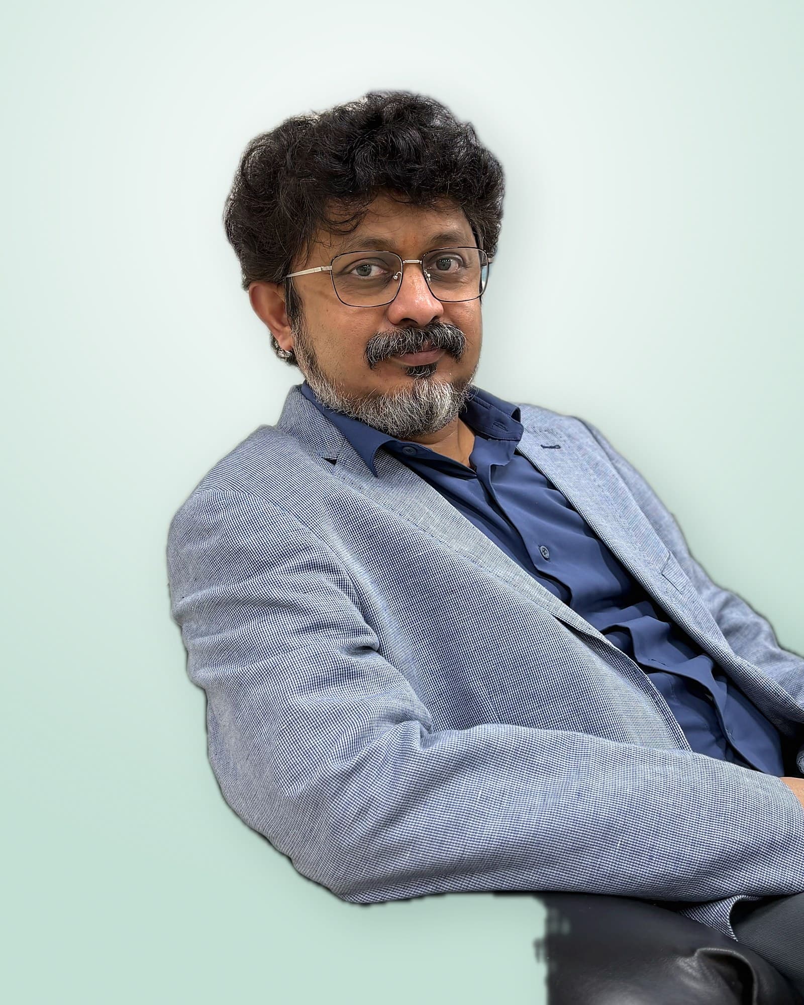 Dr. Amol Gawande seated, smiling at the camera